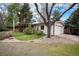 View of charming home with attached garage, complemented by mature trees and professional landscaping at 3285 Balsam St, Wheat Ridge, CO 80033
