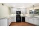 This updated kitchen offers white cabinets, granite countertops, and a sleek black appliance package at 3285 Balsam St, Wheat Ridge, CO 80033