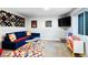 Finished basement space with colorful rug and blue sectional couch at 5347 Osceola St, Denver, CO 80212