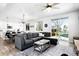 Open-concept living area with hardwood floors, a plush gray sectional, and abundant natural light at 5347 Osceola St, Denver, CO 80212