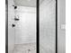 Modern walk-in shower featuring white tile, black hardware, and a sleek glass enclosure at 5347 Osceola St, Denver, CO 80212