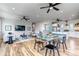 Open-concept living room and kitchen with hardwood floors, modern appliances, a large dining table and a ceiling fan at 265 Upper Glenway, Palmer Lake, CO 80133