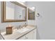 A bathroom featuring a white vanity, a large mirror, and neutral walls at 10546 Graymont Ln # D, Highlands Ranch, CO 80126