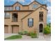 Inviting exterior elevation of a two-story townhome with a stone archway entrance and manicured landscaping at 10546 Graymont Ln # D, Highlands Ranch, CO 80126