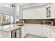 Stylish kitchen with white cabinetry, a grey backsplash, and an island with seating at 10546 Graymont Ln # D, Highlands Ranch, CO 80126