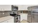 Well-lit kitchen featuring stainless steel appliances, white cabinets, and modern countertops at 10546 Graymont Ln # D, Highlands Ranch, CO 80126