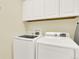 A laundry room with a washer and dryer, and white cabinets at 10546 Graymont Ln # D, Highlands Ranch, CO 80126