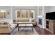 Spacious living room showcasing cozy sectional seating, fireplace, and large windows with neighborhood views at 10546 Graymont Ln # D, Highlands Ranch, CO 80126