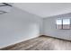 This bedroom features wood floors, a neutral wall color, and a bright window offering ample light at 2929 W Floyd Ave # 217, Denver, CO 80236