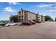 Apartment complex featuring multiple stories, balconies, stone details, and ample parking at 2929 W Floyd Ave # 217, Denver, CO 80236