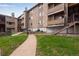 Exterior view of condo with stone accents, balconies, and well-manicured landscaping at 2929 W Floyd Ave # 217, Denver, CO 80236