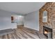 Warm living room with a stone fireplace and view into the kitchen, creating a cozy atmosphere at 2929 W Floyd Ave # 217, Denver, CO 80236
