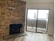 A stone fireplace and sliding door for natural light highlight the living room at 2929 W Floyd Ave # 217, Denver, CO 80236
