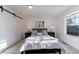 Cozy bedroom features a plush bed with decorative pillows, bedside tables, and a window with natural light at 4249 S Biscay Cir, Aurora, CO 80013