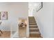 Hallway with hardwood floors leading to a living room and carpeted stairs at 4249 S Biscay Cir, Aurora, CO 80013