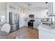 A well-lit kitchen is equipped with white cabinets, stainless steel appliances, and hardwood floors at 4249 S Biscay Cir, Aurora, CO 80013