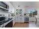 Bright kitchen showcases white cabinets, stainless appliances, and a view of the backyard at 4249 S Biscay Cir, Aurora, CO 80013