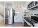 This kitchen is equipped with stainless steel appliances, white cabinetry, and hardwood floors at 4249 S Biscay Cir, Aurora, CO 80013
