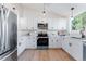Bright kitchen features white cabinetry, stainless steel appliances, hardwood floors, and a garden view at 4249 S Biscay Cir, Aurora, CO 80013