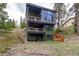 Modern three-story home with multiple balconies, situated on a hillside with green surroundings at 581 Fairview Blvd, Breckenridge, CO 80424