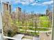 Scenic view from the balcony showcases lush green space and city buildings under a bright sky at 1200 N Humboldt St # 604, Denver, CO 80218