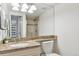 Bathroom featuring granite countertop, large mirror, shower, and neutral color palette at 1200 N Humboldt St # 604, Denver, CO 80218