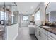 Spacious bathroom with a soaking tub, glass-enclosed shower, double windows, and neutral gray tile flooring at 5591 Farrier Pt, Castle Rock, CO 80104