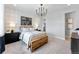 Well-lit bedroom featuring neutral decor, a comfortable wooden bed, and a striking chandelier at 5591 Farrier Pt, Castle Rock, CO 80104