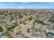 Wide aerial view showcasing the neighborhood's mature trees, and proximity to the distant cityscape at 2477 S Dover Way, Lakewood, CO 80227