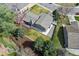 An aerial view of a charming home featuring a spacious yard, mature trees, and a cozy deck with a red umbrella at 2477 S Dover Way, Lakewood, CO 80227