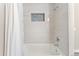 Modern bathroom showcasing tiled shower and tub with a niche for toiletries, accented by a pristine white shower curtain at 2477 S Dover Way, Lakewood, CO 80227