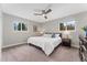 Comfortable bedroom with a ceiling fan, neutral walls, and two bright windows at 2477 S Dover Way, Lakewood, CO 80227