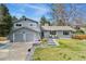 Charming two-story home with a well-maintained front yard, garage, and a cozy seating area on the front porch at 2477 S Dover Way, Lakewood, CO 80227