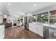 Open-concept kitchen featuring white cabinets, stainless steel appliances, and hardwood floors, seamlessly connected to living spaces at 2477 S Dover Way, Lakewood, CO 80227