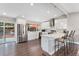 Modern kitchen featuring white cabinetry, stainless steel appliances, and an island with seating, perfect for casual dining at 2477 S Dover Way, Lakewood, CO 80227