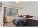 Bedroom with a large window with tree views, a soft-colored carpet, and TV at 6477 W Clifton Pl, Littleton, CO 80128