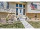 A close-up of the front entrance with an American flag and decorative landscaping at 6477 W Clifton Pl, Littleton, CO 80128