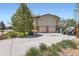 Spacious two-car garage with wide driveway, complemented by mature trees and landscaping at 6477 W Clifton Pl, Littleton, CO 80128
