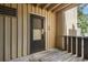 Close-up of front door #40 of condo unit with a screen door, vertical siding and wooden deck at 8050 Niwot Rd # 40, Niwot, CO 80503