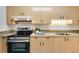 Functional kitchen featuring wooden cabinets, stainless steel stove, and mosaic backsplash accents at 8050 Niwot Rd # 40, Niwot, CO 80503