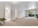 Open living room with carpet, balcony, and view into hallway with tiled bath and partial view of kitchen at 8050 Niwot Rd # 40, Niwot, CO 80503