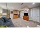Spacious basement with a large gray couch, TV, stairs, white door, and wood storage at 5270 Tabor St, Arvada, CO 80002