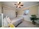 Comfortable bedroom with a ceiling fan, a bed, and a window offering natural light and custom shelving at 5270 Tabor St, Arvada, CO 80002