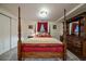 Bedroom with a four-poster bed, red bedding, decorative pillows, and a dark wood dresser and closet at 5270 Tabor St, Arvada, CO 80002