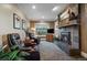 Comfortable living room featuring a stone fireplace, cozy seating, and a window with natural light at 5270 Tabor St, Arvada, CO 80002