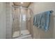 Tiled shower with a glass door and chrome fixtures, accompanied by a towel rack with plush blue towels at 5270 Tabor St, Arvada, CO 80002