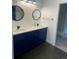 Bathroom with blue vanity, double sinks, black fixtures, and a walk-in shower at 9642 E Idaho Pl, Aurora, CO 80247