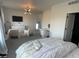 Bright bedroom with a large bed, TV, make up desk, and modern light fixture at 9642 E Idaho Pl, Aurora, CO 80247