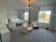 Spacious bedroom with modern lighting, large windows, and cozy seating area at 9642 E Idaho Pl, Aurora, CO 80247