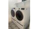 Convenient laundry room with modern, front-loading washer and dryer units, on pedestals at 9642 E Idaho Pl, Aurora, CO 80247